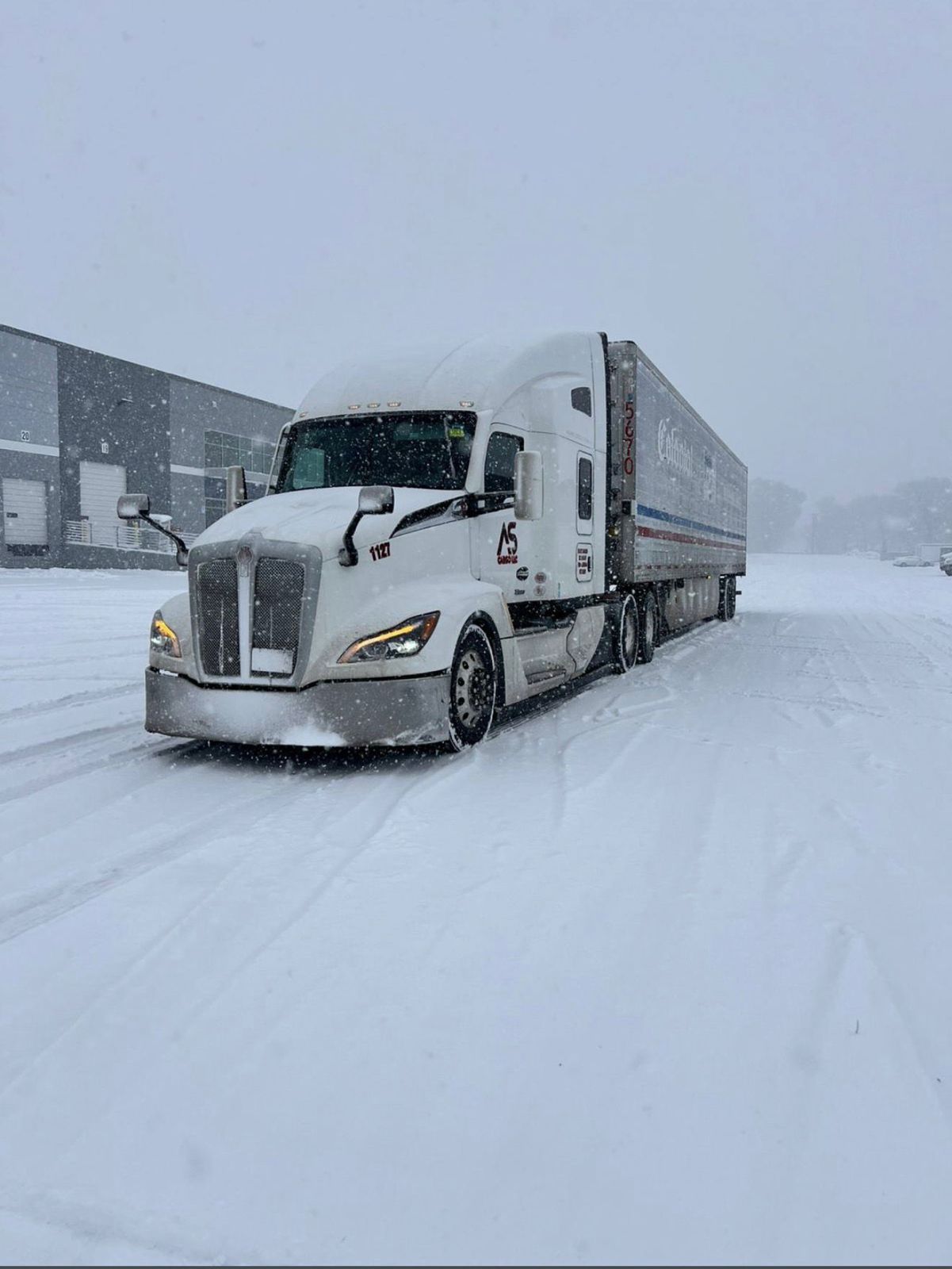 ASCargo logistics truck on a Western U.S. highway at sunset